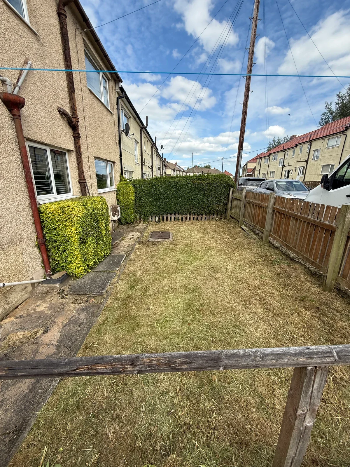 The same garden after clearance, with shorter growth and the route visible