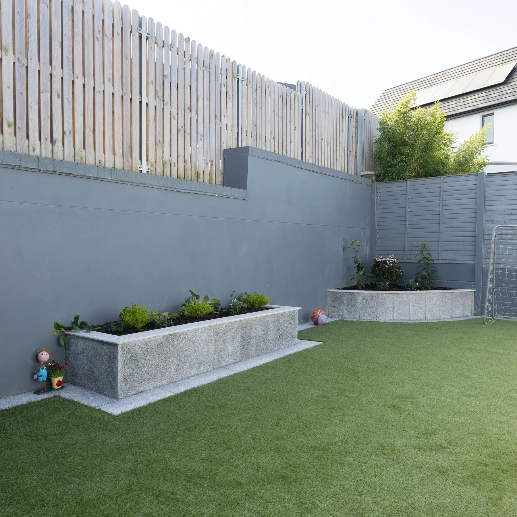 Artificial grass bordered by paving in a garden