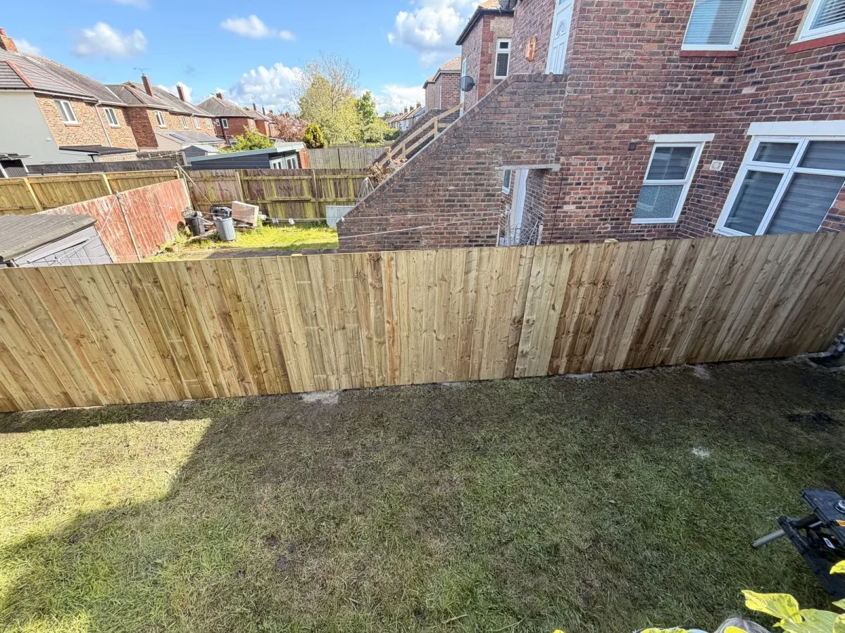 The same garden boundary with a continuous new vertical timber fence